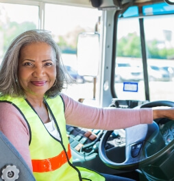 Female bus driver sitting in seat smiling