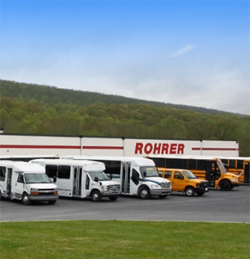 Row of Rohrer bus inventory in front of building